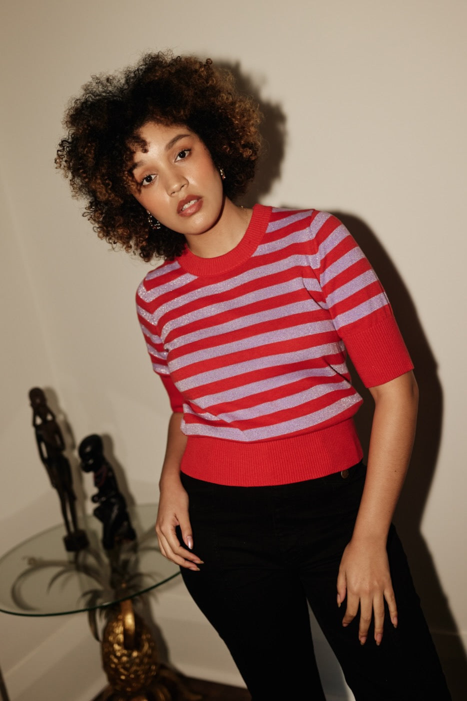Woman wearing the Frock Me Out RED and DISCO LILAC Stripe Knit paired with Black Jeans